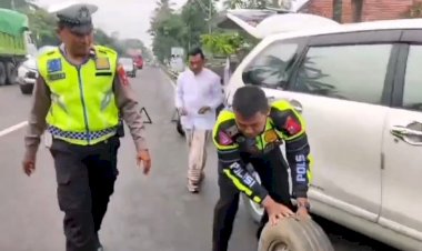 Cepat-Dekat-dan-Bersahabat-Polisi-Bantu-Pengendara-yang-Kesulitan-Saat-Ban-Mobilnya-Bocor-di-Jalan-Raya-Lumajang